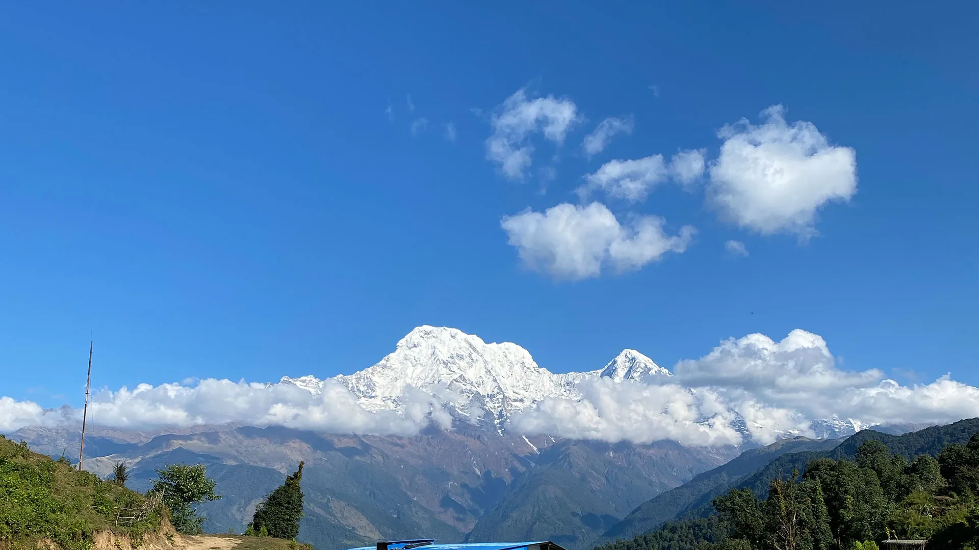Snow-capped peaks of the Annapurna mountain range under a clear blue sky in Nepal.